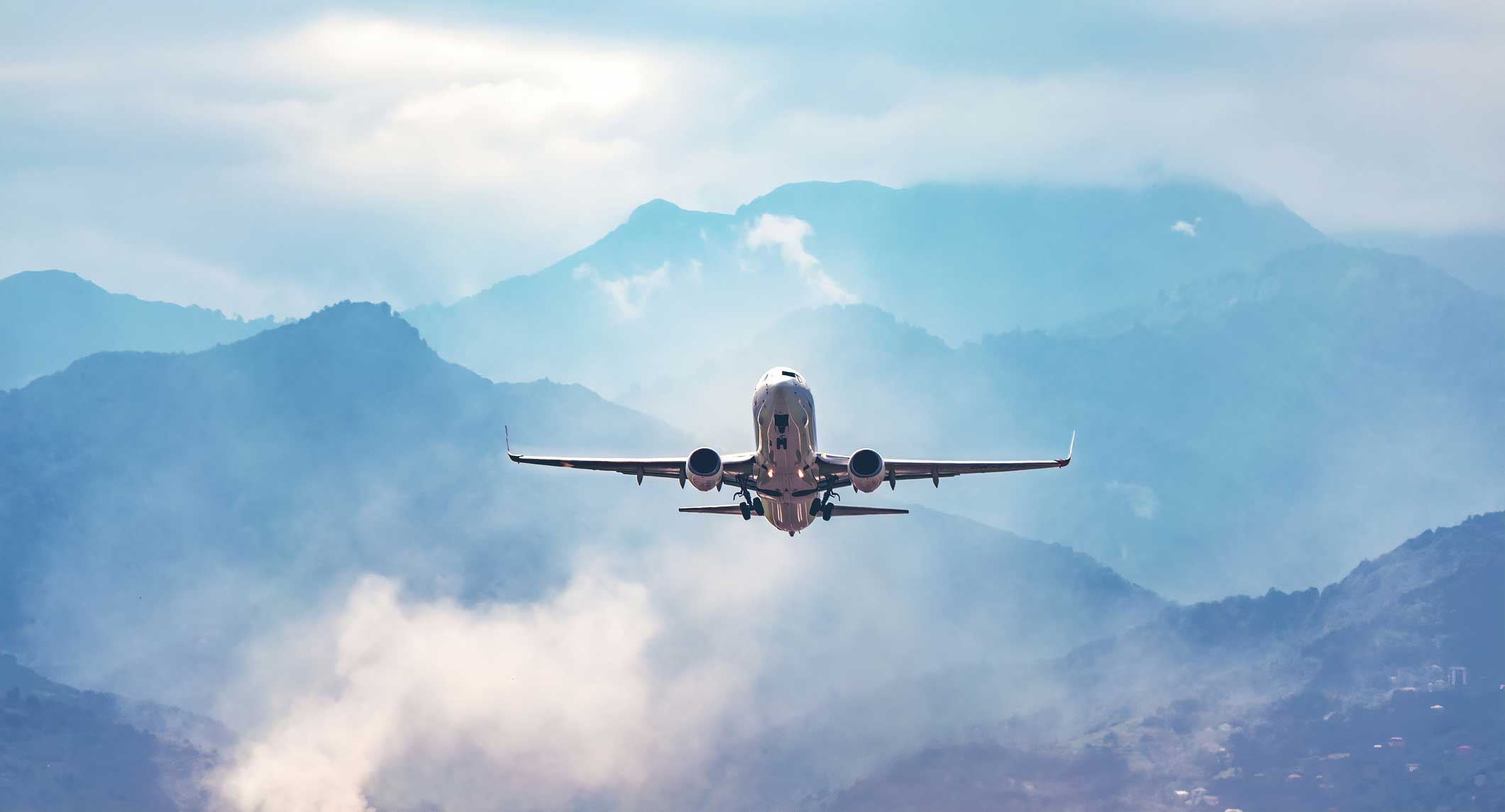 airplane taking off from the airport with mountains